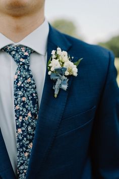 groom in his wedding day attire in a navy suit with floral tie Groom Getting Ready Photos, Floral Tie Wedding, Groom Suit Navy, Neutral Wedding Decor, Navy Groom, Navy Suit Wedding, Twilight Wedding, Grooms Party