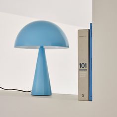 a blue lamp sitting on top of a table next to a box and a book