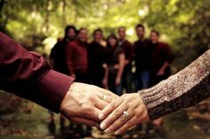 a group of people holding hands in the woods