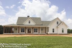 a large white house sitting on top of a lush green field