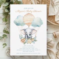 a baby shower with an elephant and hot air balloon in the sky on it's back