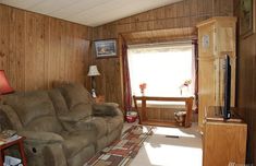 a living room filled with furniture and a flat screen tv sitting on top of a wooden wall