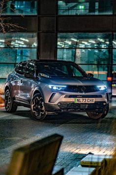 an suv parked in front of a building at night