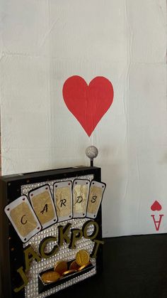 a card holder with playing cards and a red heart