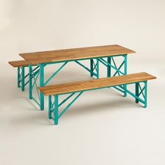 three wooden benches sitting next to each other on top of a white table with green legs