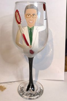 a wine glass with a man holding a toothbrush