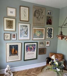 a living room filled with lots of framed pictures on the wall above a coffee table