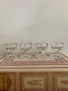 four glass bowls sitting on top of a box