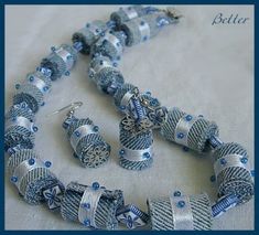 a blue and white beaded necklace and earring set with matching bracelets on a table