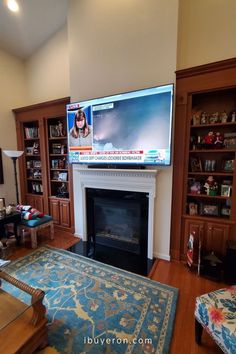 a flat screen tv mounted to the side of a fireplace in a living room next to a blue rug