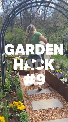 a girl is walking up some steps in the garden with her back to the camera