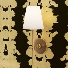 a lamp on a wall next to a black and gold wallpaper with white lampshade