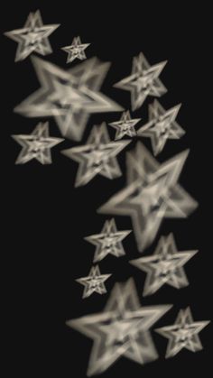 many white stars are arranged in the shape of an arrow on a black background with blurry edges