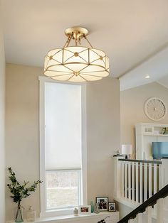 a white staircase with a light fixture hanging from the ceiling