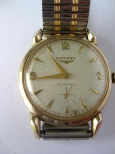 "Fully serviced Vintage Longines automatic dress watch with Gold filled case. As a useful fact, gold filled cases are different from gold plated ones - they have a thick layer of gold and are less subject to gold loss than plated ones. Roman and baton markers on cream coloured dial with lovely subseconds dial. Some slight natural patina(please see all pictures). Unusual  hare ear lugs around the dial. Case marked ,\"10k gold filled, L&K\"- Modern bi-colour elastic wristband.  A beautiful vintage timepiece probably from the 1960s or 70s keeping good time. A pleasure to wear. Dimensions (approx) Case width 35mm.  (41mm including crown) **PLEASE NOTE**  All watches and clocks are checked & cleaned and are in proper working order. Where the item has been recently serviced, this is indicated in Gold Chronometer Watch For Weddings, Gold Automatic Round Watch Accessory, Gold Automatic Watch Accessories, Self-winding Watches With Round Dial For Anniversary, Self-winding Watches For Anniversary, Classic Self-winding Watch For Anniversary, Anniversary Self-winding Watch With Round Dial, Anniversary Self-winding Watches With Round Dial, Retro Gold Watches With Polished Finish