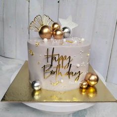 a birthday cake with gold and silver decorations