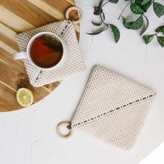 a cup of tea on a table next to a cloth with a lemon slice in it