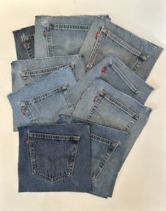 five pairs of jean pants with red stitchs on the back and sides, all lined up together