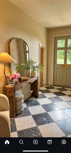 a room that has a checkered floor and a large mirror on the wall above it