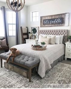 a dog laying on top of a bed in a room with white walls and furniture