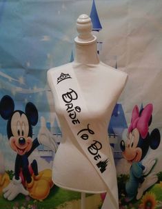 a white mannequin with mickey mouse and minnie mouse on it's back