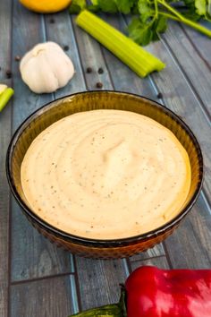 a bowl filled with dip surrounded by vegetables