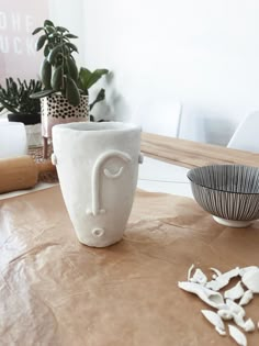 a white vase sitting on top of a wooden table