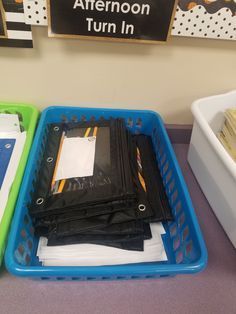 three plastic bins filled with papers on top of a table