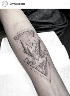 a black and white photo of a person's arm with a triangle tattoo on it