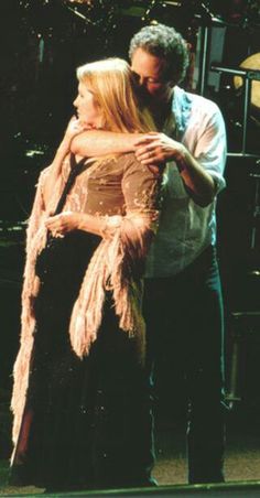 two people standing next to each other on stage