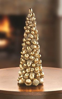 a small gold christmas tree sitting on top of a wooden table