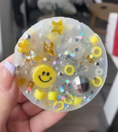 a person holding a smiley face bubble with stars and bubbles on it's side