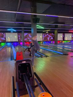 a person riding a skateboard on top of a wooden bowling alley filled with bowling balls