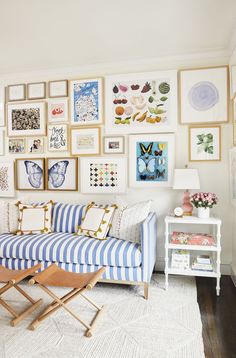 a living room with pictures on the wall and a couch next to a table in front of it