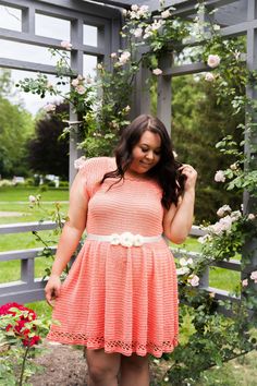 a woman in an orange dress is posing for the camera with her hands on her hips