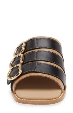 Whether you're polishing up your casual office look or dressing up for brunch, this buckled slide sandal will enhance a variety of looks. Leather upper and lining/rubber sole Made in Portugal Black Owned/Founded Modern Slip-on Mules With Buckle Closure, Open Toe Slides With Gold Buckle For Spring, Spring Open Toe Slides With Gold Buckle, Spring Slides With Gold Buckle And Open Toe, Chic Flat Footbed Sandals With Buckle Closure, Leather Footbed Sandals With Gold Buckle For Spring, Designer Round Toe Sandals For Work, Modern Mules With Tang Buckle And Round Toe, Designer Workwear Sandals With Round Toe