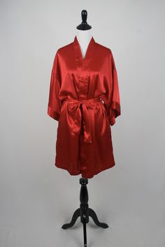 "1980s kimono style wrap robe. Polyester satin fabric. Short sleeves. Front patch pockets. Fastens with a sash belt. Label reads, \"Lingerie Cacique, 100% polyester made in Hong Kong, S.\" Freshly laundered. Excellent condition. Measurements: Shoulders = 23\" Bust = 46\" Waist = 46\" Hips = 46\" Sleeve = 10\" Length from top of shoulder to hem = 35\" All measurements are taken with the garment flat, doubled for the bust (chest), waist, hips, and circumference. Please make sure you leave yourself Long Red Kimono For Loungewear, New Braunfels, Sash Belts, Hawaiian Dress, Sash Belt, Kimono Style, Peasant Dress, Womens Robes, Polyester Satin