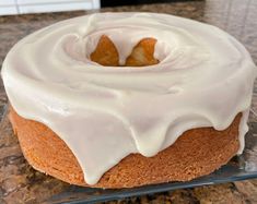 a frosted donut sitting on top of a glass cake plate covered in icing