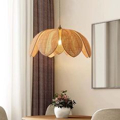 a dining room table with chairs and a large light fixture hanging from it's ceiling