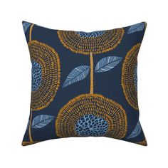 a blue and yellow pillow with an orange flower design on the front, along with a black background