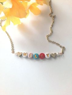 Simply adorable, colorful and oh, so sweet! This cute and fun necklace can be personalized with any name, word or phrase that you would like for your personalized necklace. Letters are randomly chosen from the color palette shown in the photos for a unique personalized style. The beads are made from a plastic resin material with an inlay of a gold printed letter. The Chain is a 12K gold plated hand cut chain. We hand cut each chain for all our guests. We ensure that each necklace is carefully crafted with all the personal details for your special order.  N E C K L A C E ~ L E N G T H S Lengths available: 12 Inches, 13 Inches, 14 Inches, 15 Inches, 16 Inches, 18 Inches and 20 Inches. If you need a length that is not offered in the dropdown menu, please reach out to us and we will be more th Necklace For Kids, Toddler Necklace, Artisan Gift, Girl Jewelry, Kids Birthday Gifts, Bright Colored, Childrens Jewelry, Letter Beads, Birthday Jewelry Gift