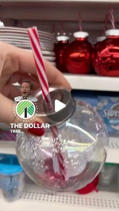 a person is holding a candy cane in a glass bowl on the shelf at dollar