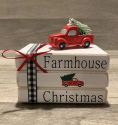 a stack of books with a red truck and christmas tree on top that says farmhouse