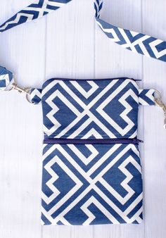 a blue and white purse sitting on top of a wooden table next to a toothbrush holder