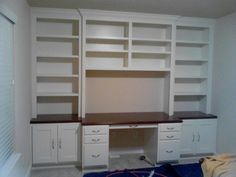 an empty room with white cabinets and black counter tops on the wall, along with a blue rug