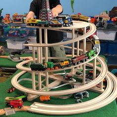 a young boy playing with his toy train set