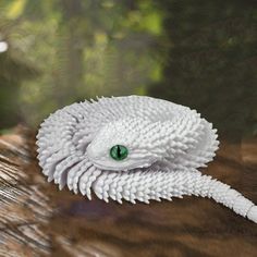 a close up of a white snake with green eyes