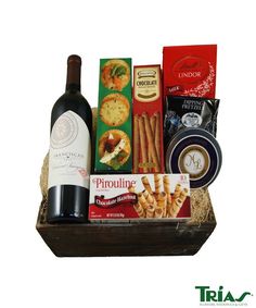 a bottle of wine and some snacks in a basket