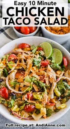 chicken taco salad in a white bowl with limes and tomatoes on the side