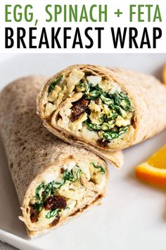 an egg spinach and feta breakfast wrap on a white plate with orange slices